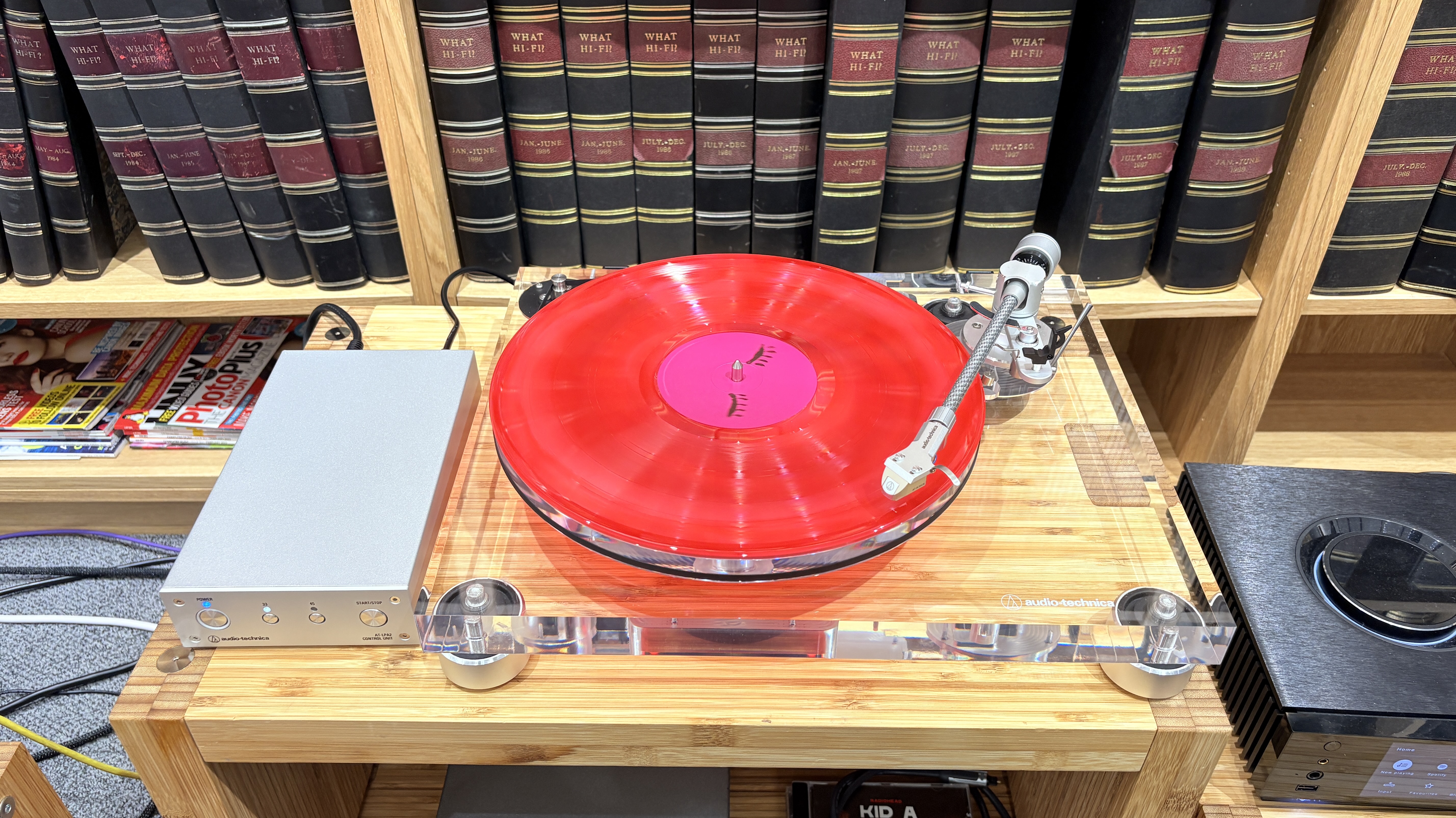Audio-Technica AT-LPA2 turntable on wooden rack with books in background