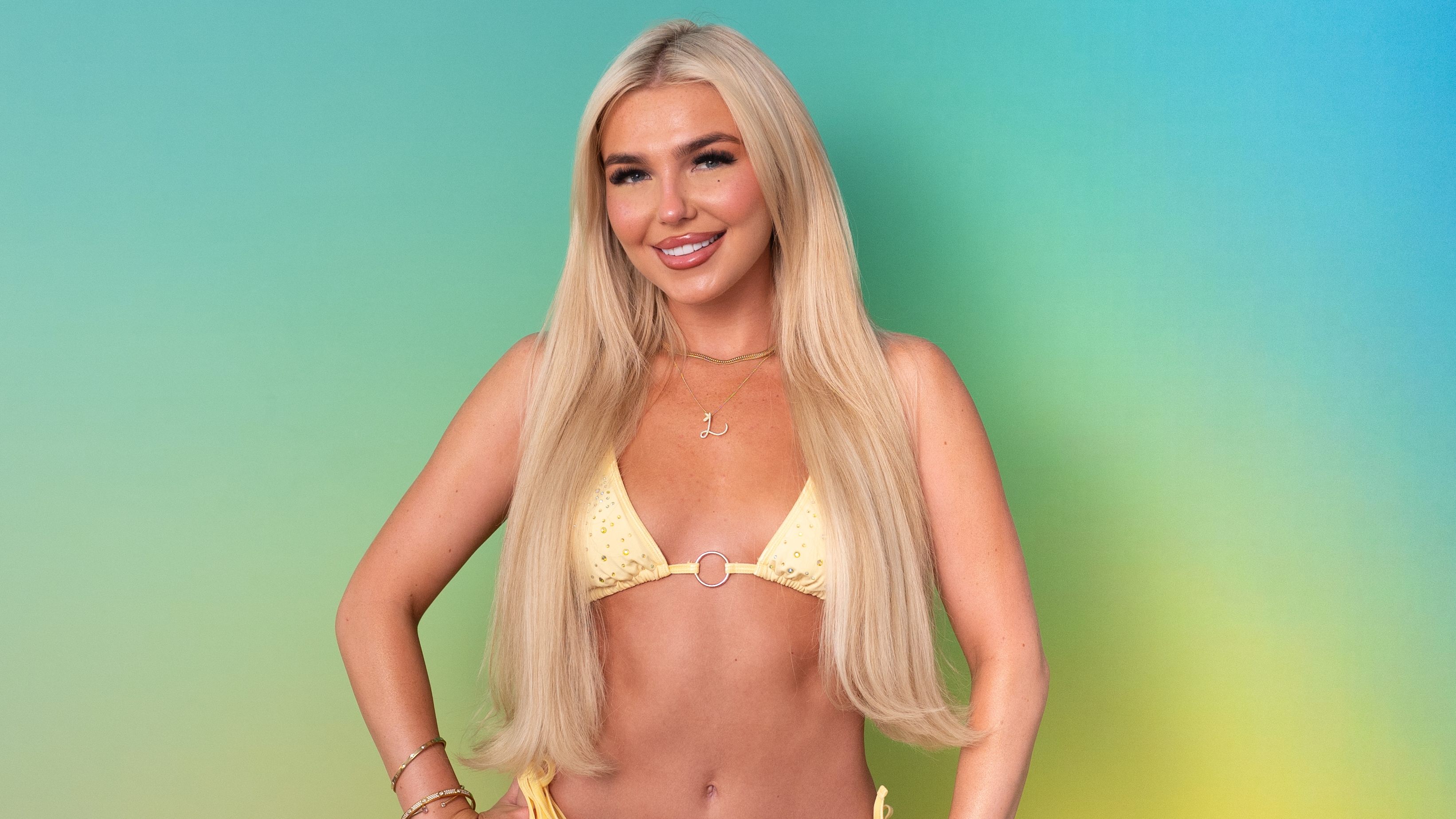 Lucy standing in swimwear in front of a green background.