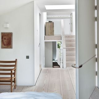 master bedroom with white walls and wooden flooring