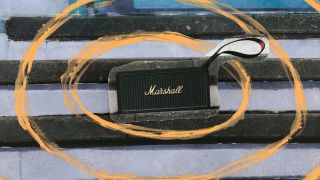 A photograph of the Marshall Middleton II portable Bluetooth speaker on a set of stairs, with stylised yellow paint swirls added to the image.