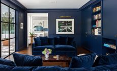 dark blue living room with blue velvet sofa by Ryan Street