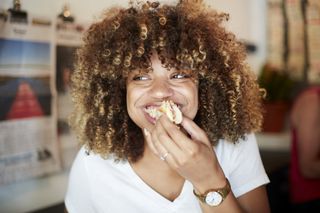 Intuitive eating: A woman eating a bagel