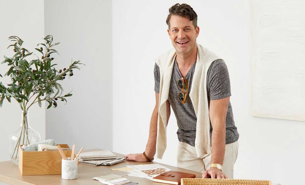 nate berkus in front of a desk with interior design materials