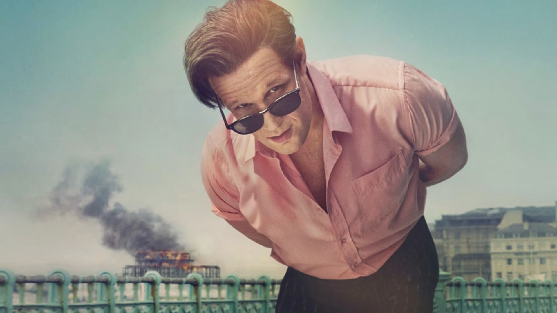 an image of matt smith in the death of bunny munro, standing in front of the old brighton pier which is on fire