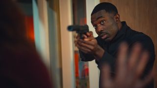 Paapa Essiedu as elmore fitch pointing a gun in 'Black Doves.'