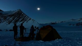 Chilean and U.S. scientists look at a solar eclipse from the Union Glacier in Antarctica on Dec, 4, 2021.