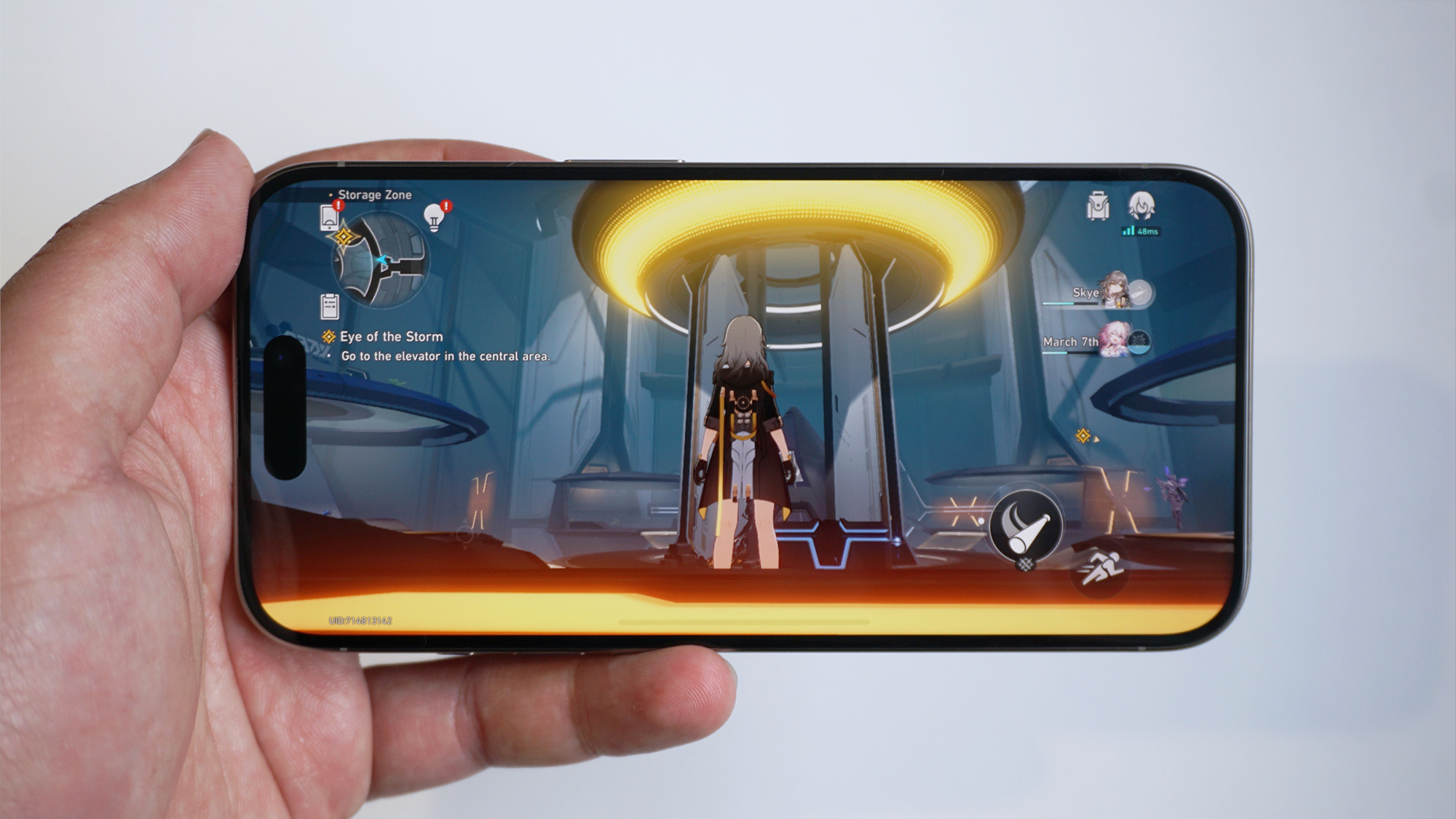 En mobiltelefon av typen iPhone 15 Pro med spillet Honkai Impact på skjermen.