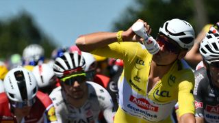 Mathieu van der Poel wearing the yellow Tour de France jersey taking a drink