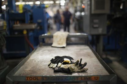 A glove is left behind on a factory table.
