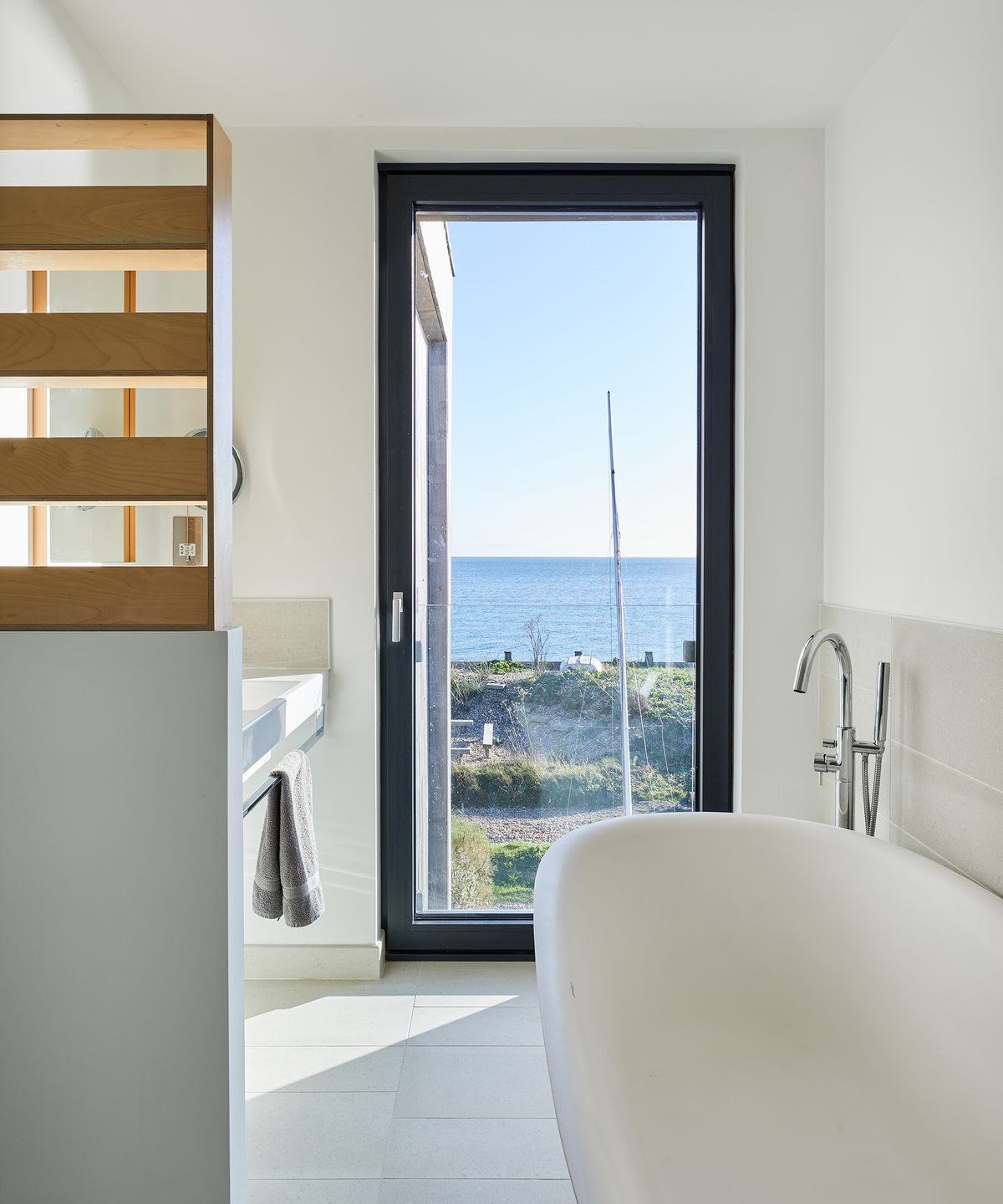 A bath with a view out of a glass floor to ceiling window