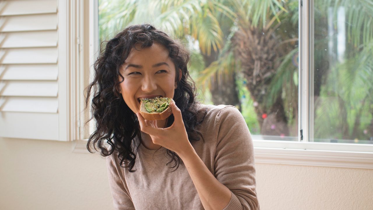 Woman eating an avocado