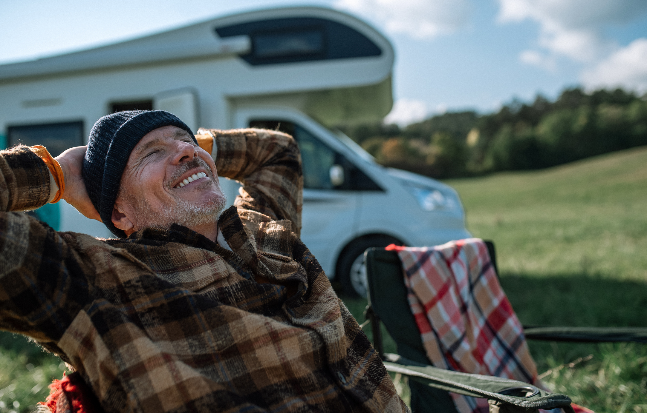 Man sitting by his RV smiling