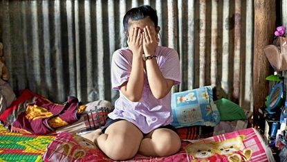 cambodian girl covering her face