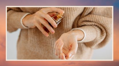 woman with beige jumper on spraying perfume onto her wrist