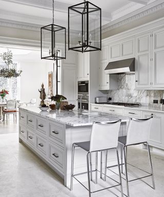 Modern white kitchen ideas with a marble-topped Island and white painted cabinets