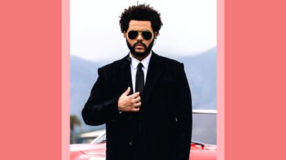 The Weeknd in a black suit, standing in front of red car as he performs for the 2021 Billboard Music Awards, broadcast on May 23, 2021 at Microsoft Theater in Los Angeles, California./ in a red template