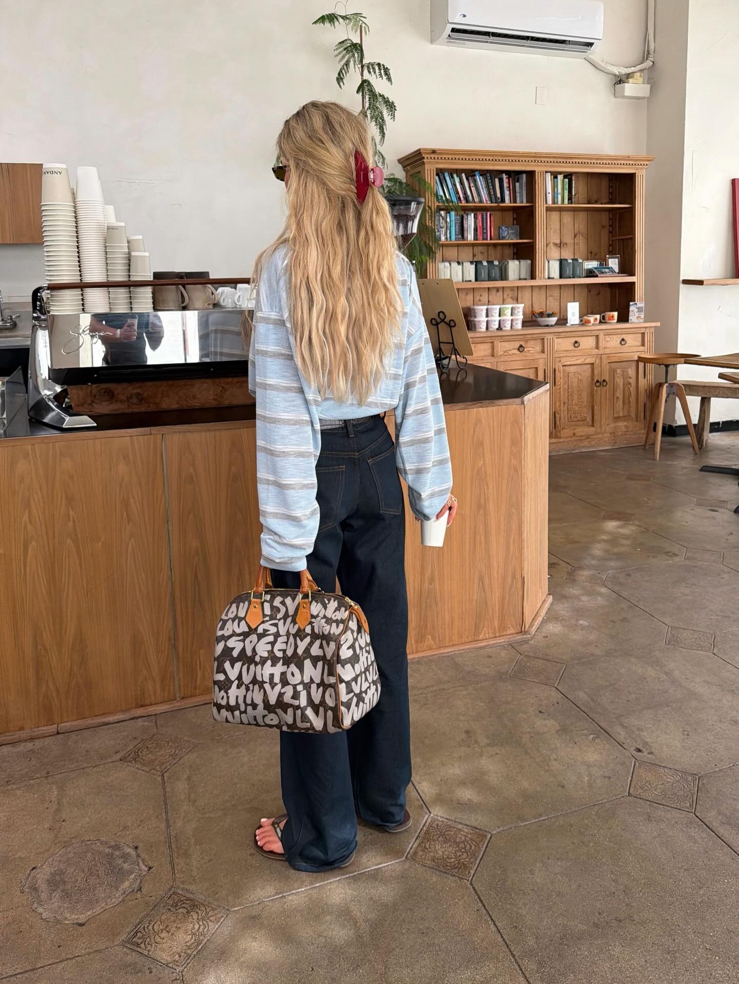 Creator @emilisindlev ordering a coffee with long, wavy hair in a claw clip