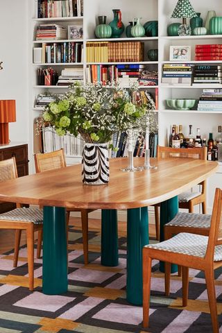 maximalist dining room with shelving and vase of flowers