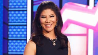 Julie Chen Moonves on the Big Brother stage in a black dress