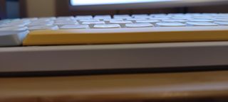 A white NuPhy Air75 V2 keyboard on a wooden desk