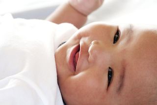 An Asian baby smiling.