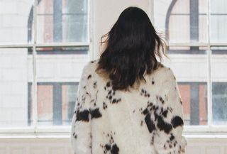 A model wearing a cream-and-brown faux fur animal print coat from Zara.