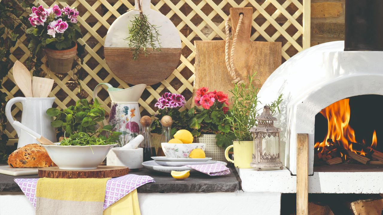 A pizza oven with pots of herbs and plants