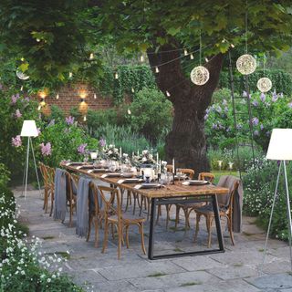garden lighting ideas alfresco table dressed with lights set around festoon lights and pendants and solar powered floor lamps
