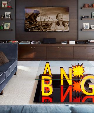 Modern bang coffee table with blue suede sofa and TV mounted into wall unit