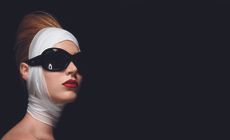 woman with sunglasses and ace bandages wrapped around her face and neck