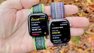 Close-up of the Apple Watch SE 3 and Apple Watch Series 11 in a user's hand with a colorful, out-of-focus background