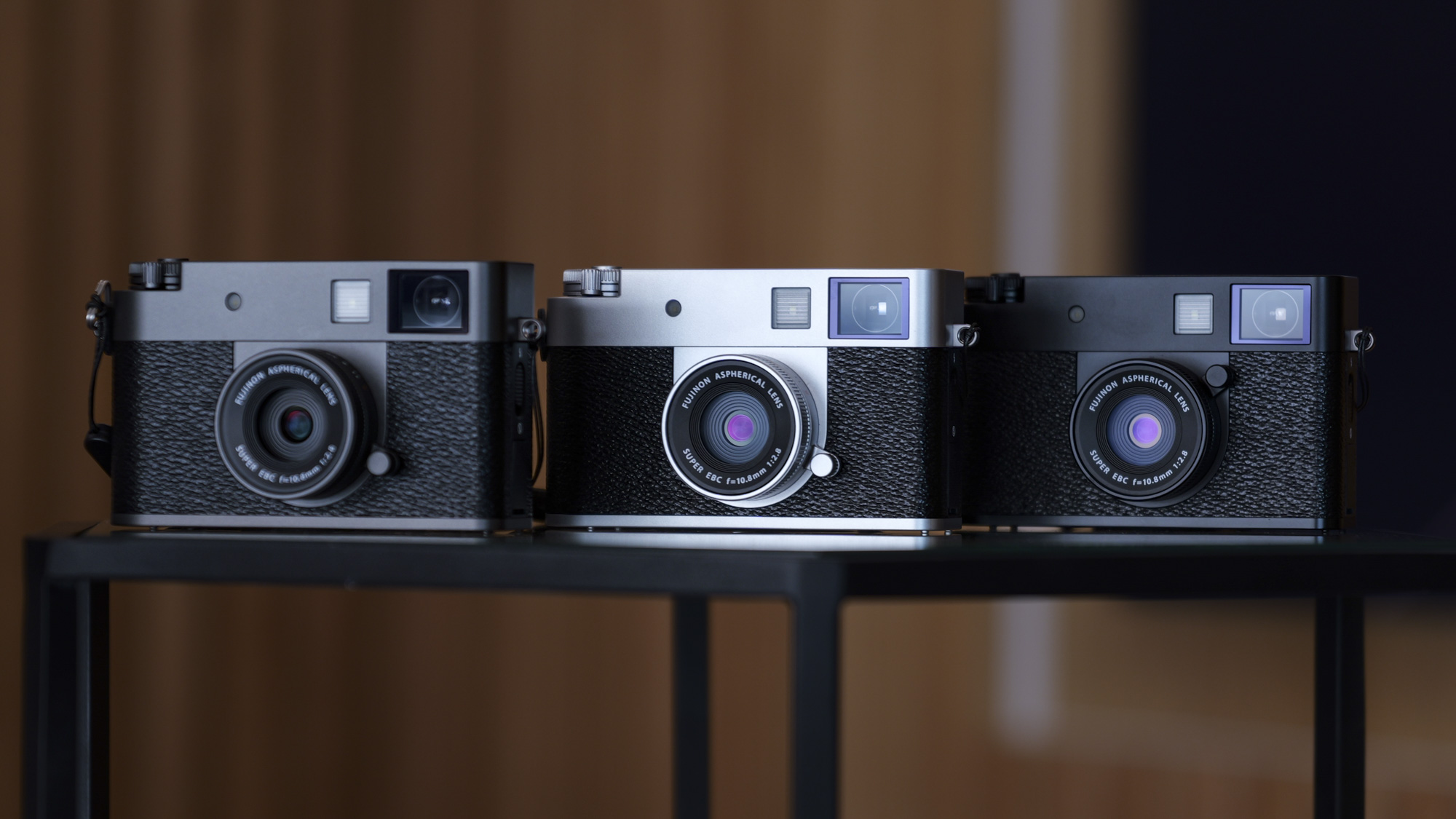 Three Fujifilm X half compact cameras side by side, each a different color