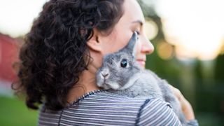 Rabbit sitting on brunette woman's shoulder