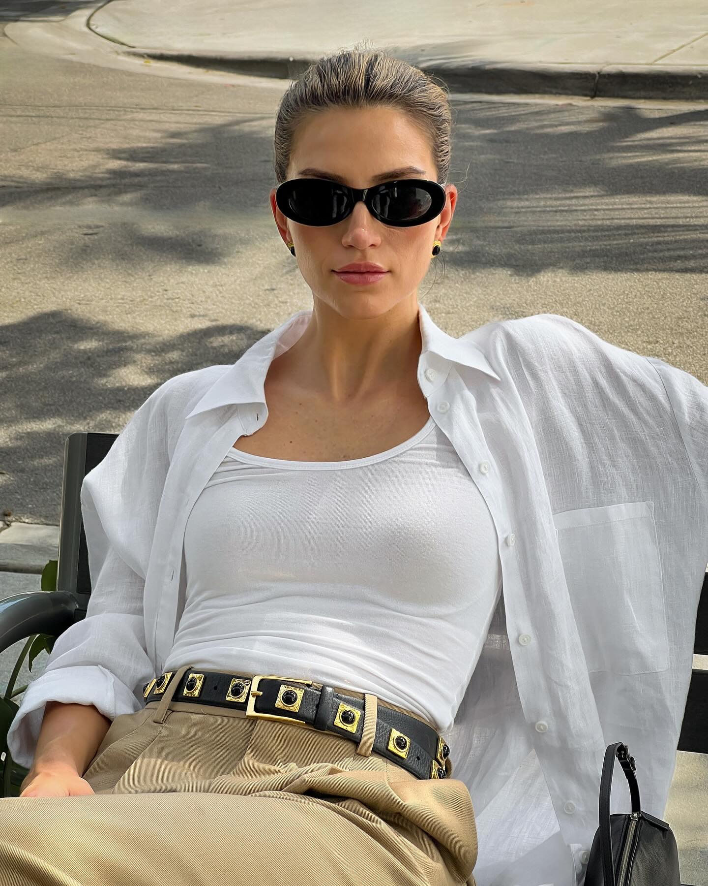 woman in sunglasses, white shirt, and tank top