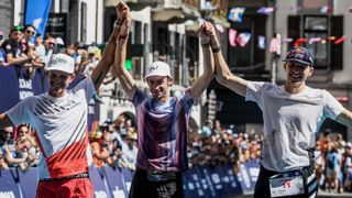 second placed France's Mathieu Blanchard (L), winner Spain's Kilian Jornet (C), and third placed Britains Thomas Evans (R) celebrate on the podium of 19th edition of the Ultra Trail du Mont Blanc