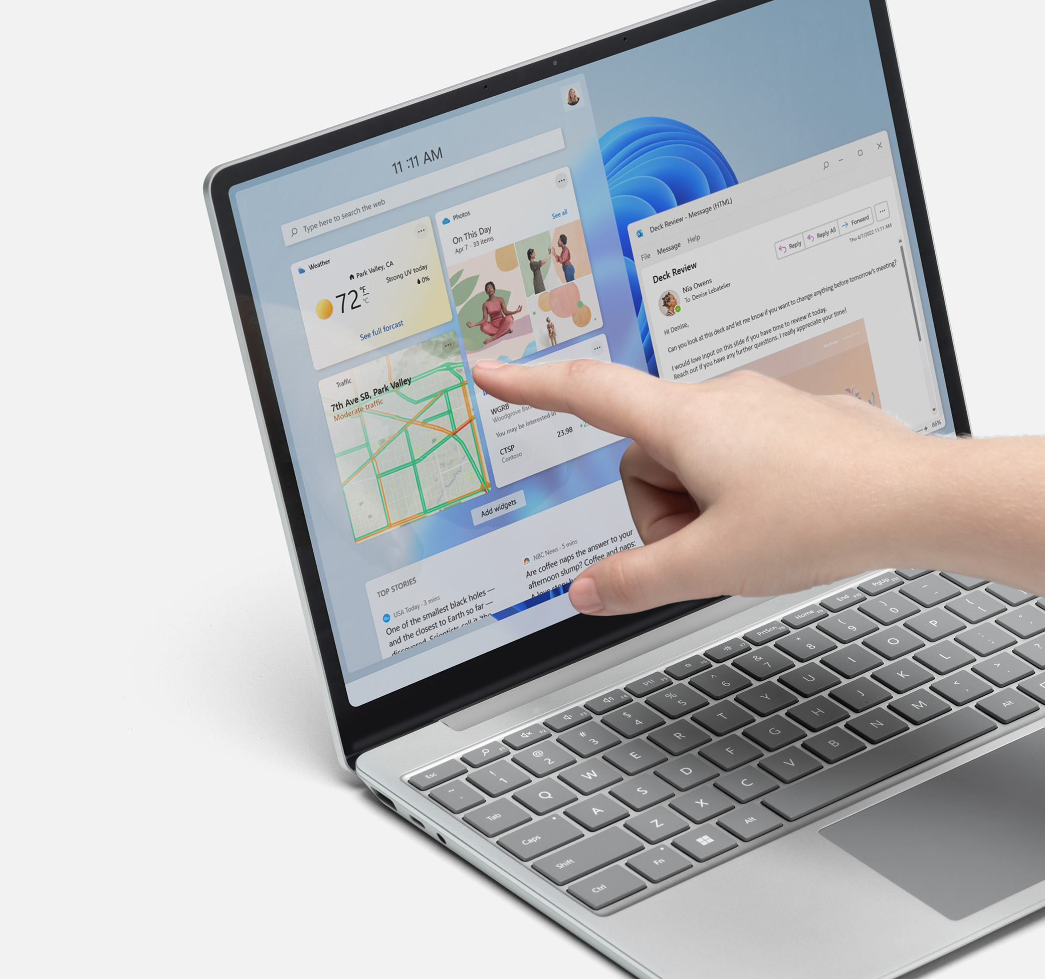 Surface Laptop Go 2 showing finger touching touchscreen w/ Windows 11 on it