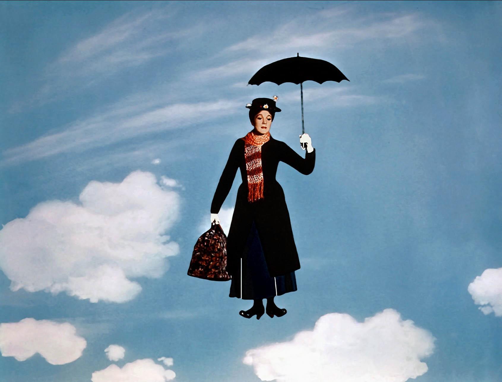 Julie Andrews as Mary Poppins holding an umbrella and flying through a blue sky with several white, fluffy clouds