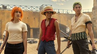 Nami, Luffy, and Zoro smile as they look at something off camera in One Piece on Netflix