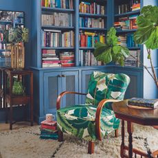 Living room with blue built in bookshelf and green armchair.