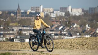 Woman riding a Shimano ebike on a trail overlooking a city