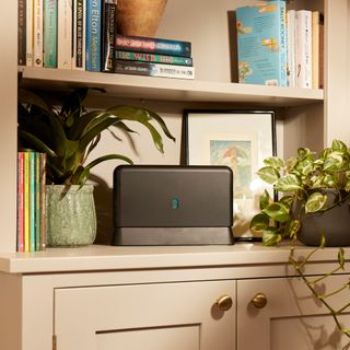 A wifi router on a bookshelf