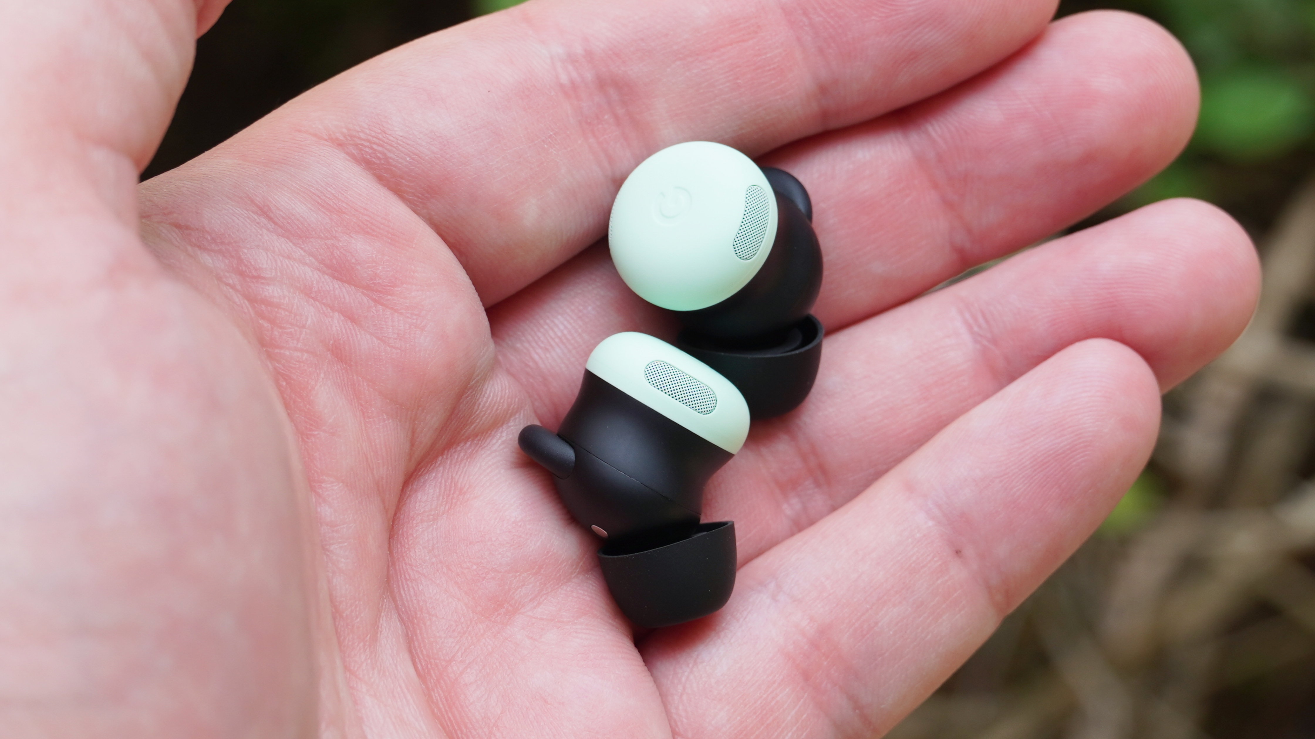 The Google Pixel Buds Pro 2 in the Mint colorway in the hand.