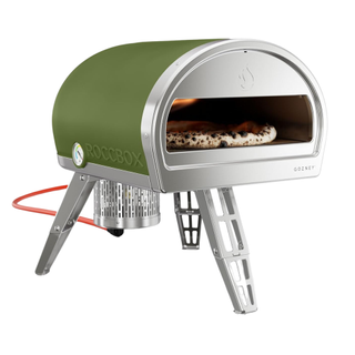 A green portable outdoor pizza oven by Gozney