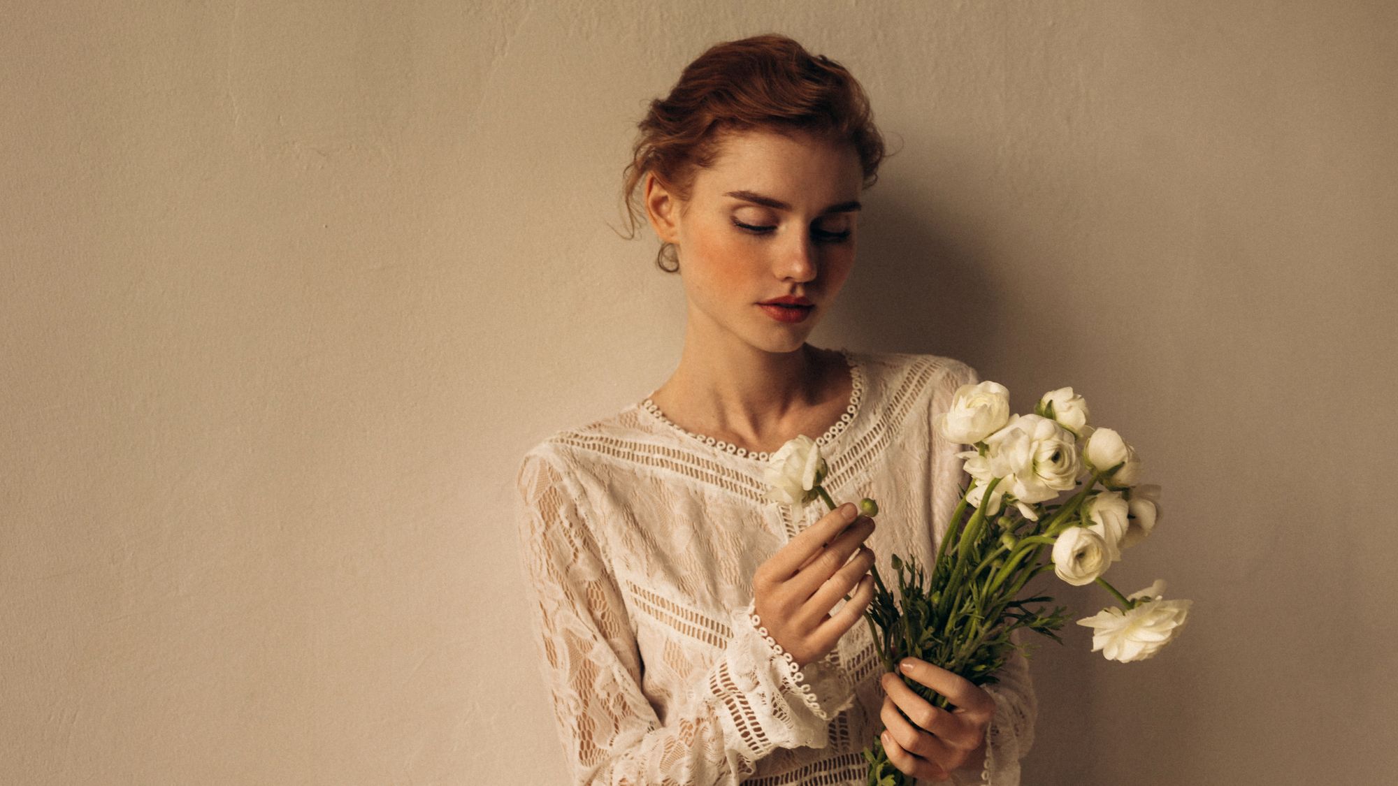 a model in a wedding dress holding a bouquet of ranunculus - wedding beauty timeline
