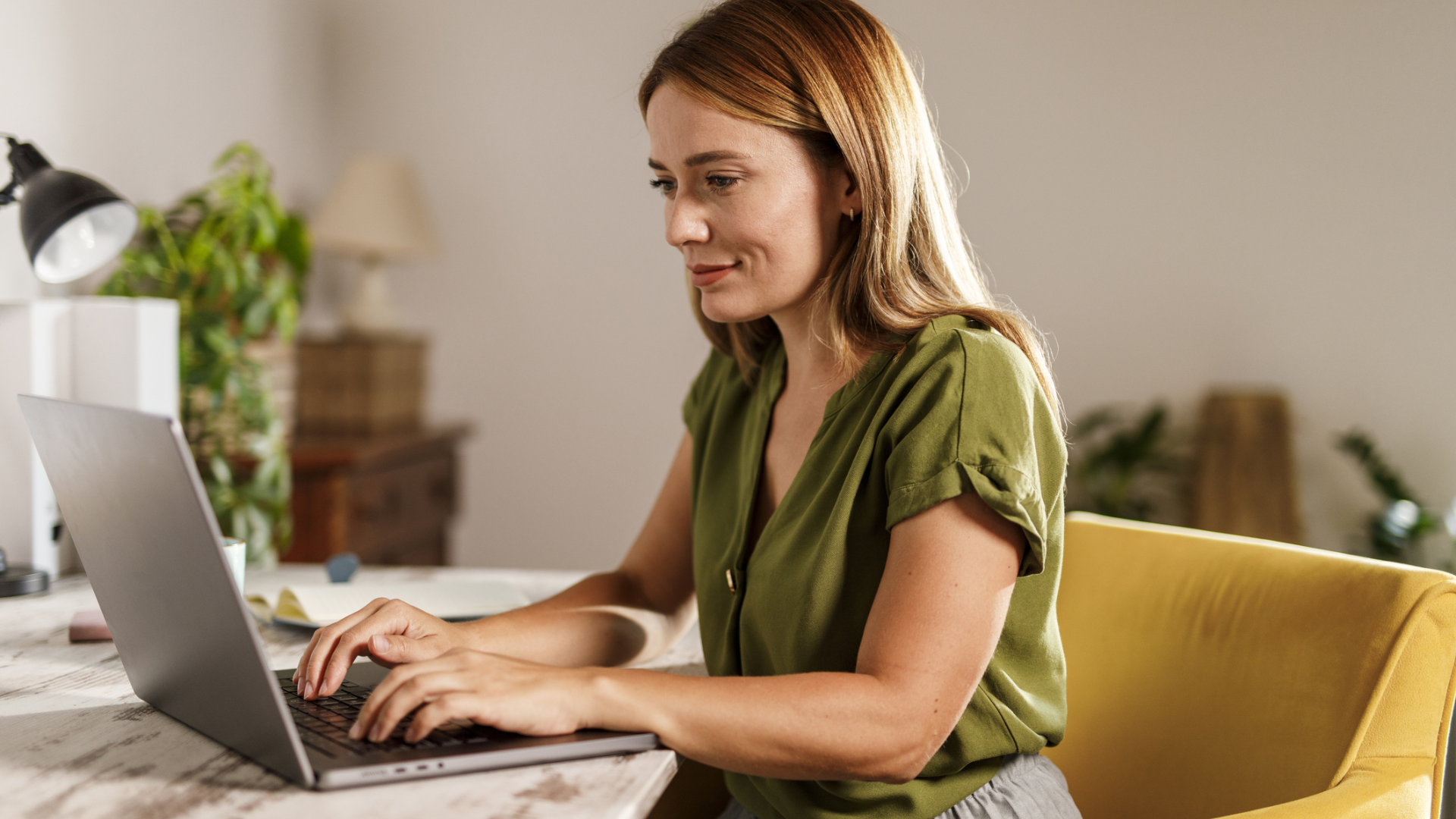 A woman on a laptop in a home office checking her emails