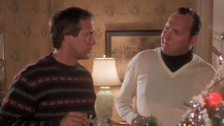 Chevy Chase talking to Randy Quaid by a christmas tree