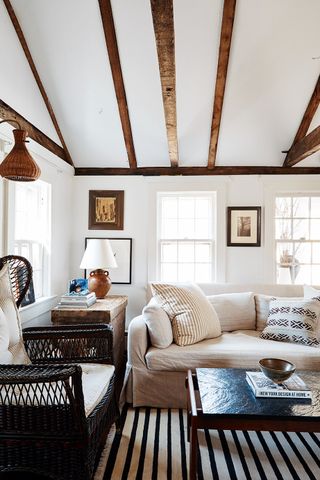 white living room with wood beams on the ceiling and beige sofa