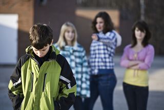 Three female bullies taunt a passing male student.