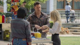 Christopher Smith and alternate Emilia Harcourt standing near hot dog cart in Peacemaker
