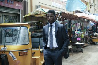 Toheeb Jimoh as Tunde, wearing a suit